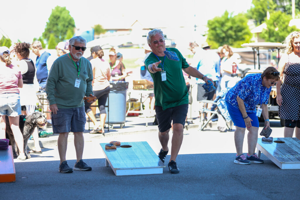 Owners playing cornhole outside at the rally