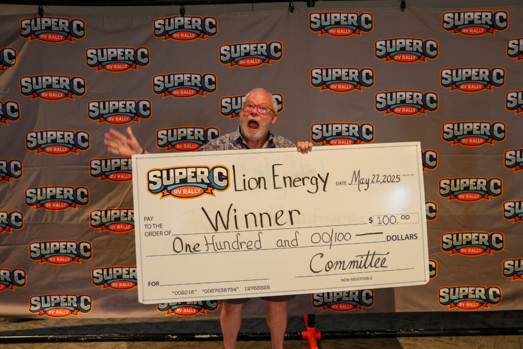 Giveaway winner holding a Lion Energy prize check